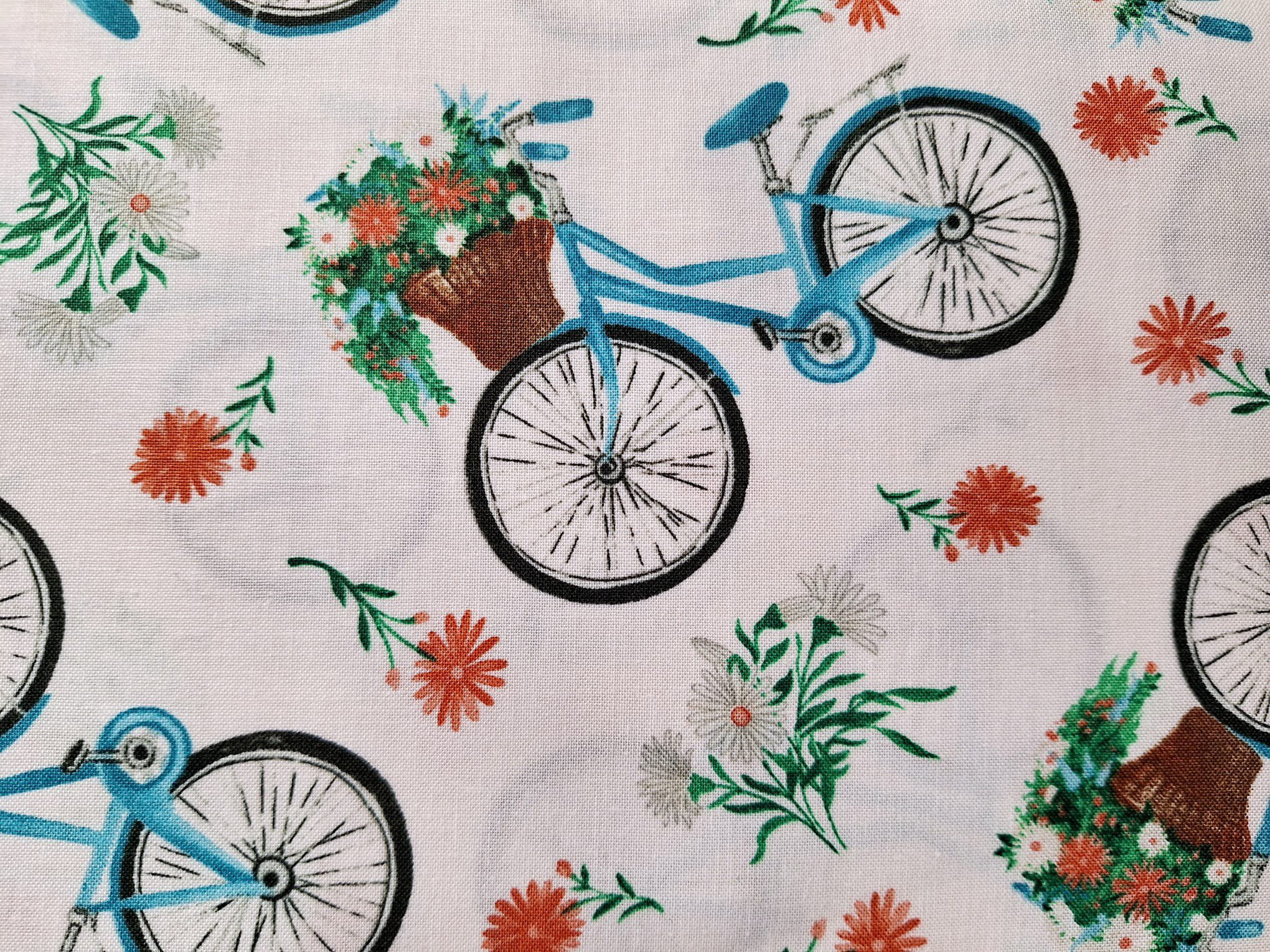 Tela de algodón blanco con grandes dibujos de bicicletas azules con cestas de flores de la colección Rural Fantasy.