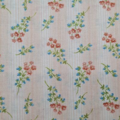 tela de algodón tipo patchwork, dibujada con flores rosas y azules sobre fondo rosa