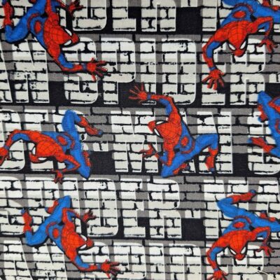 Tela de algodón gris con estampado de Spider-Man escalando en una pared de ladrillos con letras de cómic.
