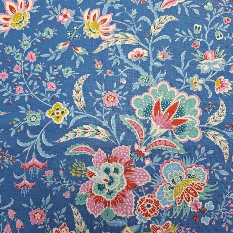 Tela de patchwork de algodón en fondo azul con estampado floral colorido en tonos rosa, rojo, verde, amarillo y blanco.