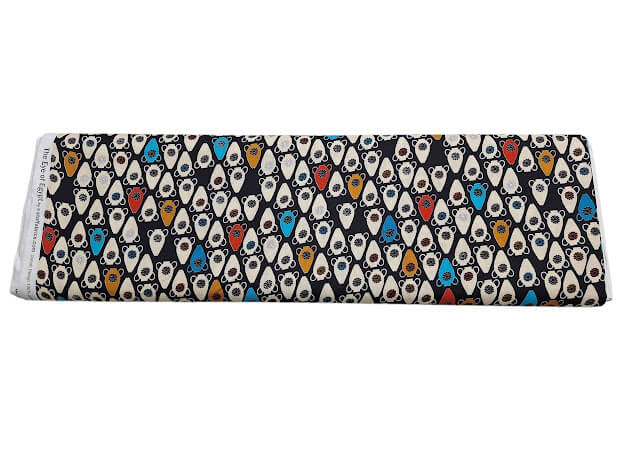 Rollo de tela de algodón negro con estampado de jarrones y vasijas egipcias en azul, naranja y blanco.
